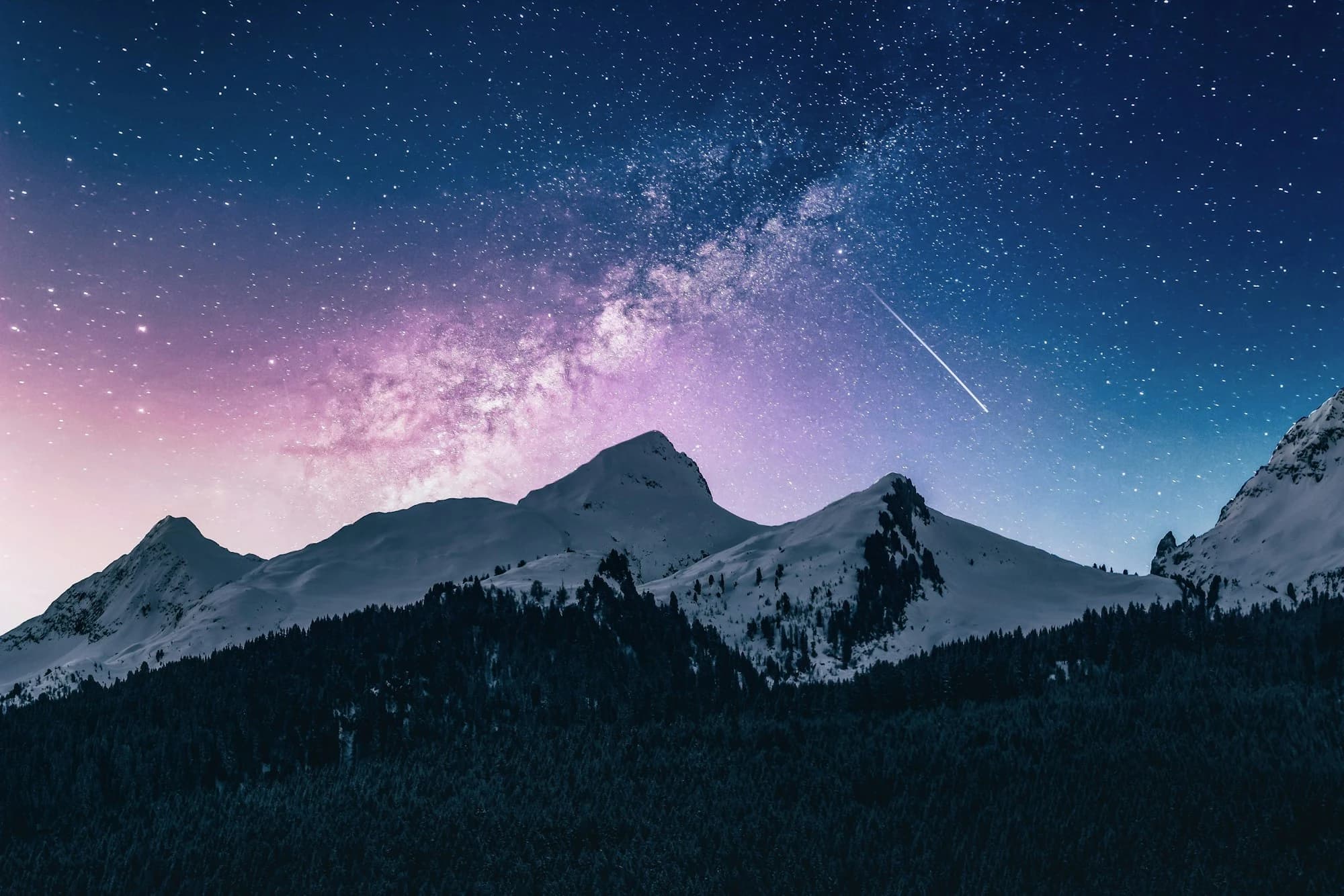 Stars over snowbound peaks at night